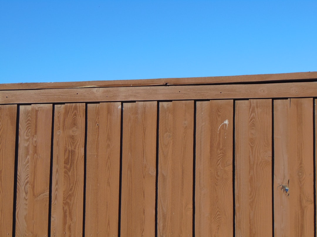 a wooden fence with a blue sky in the background 1